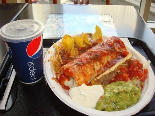 A plate of Mexican food with a drink.